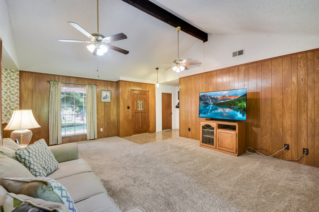 301 Navajo Trail Georgetown, TX 78633 - Photo 20 of 35 Living area with a ceiling fan, wood walls, carpet floors, beam ceiling, and high vaulted ceiling