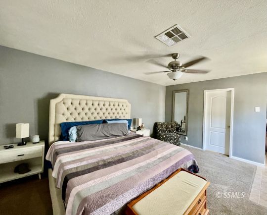 1009 West Iowa Avenue Ridgecrest, CA 93555 - Photo 21 of 26 a bedroom with a large bed and a chandelier