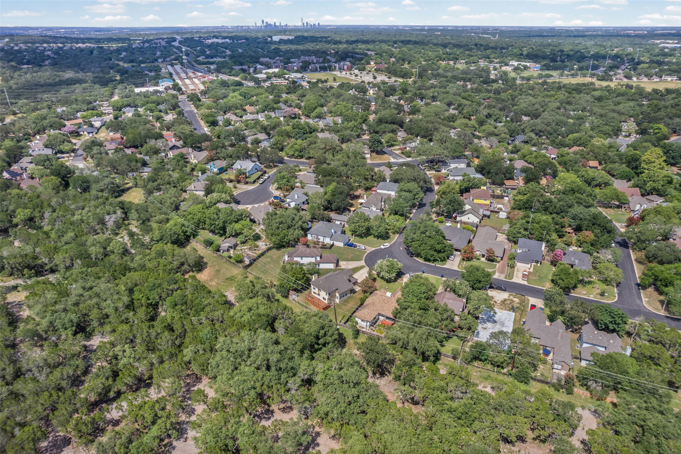 3011 Wadsworth Way Austin, TX 78748 - Photo 32 of 35 An aerial perspective reveals a harmonious community nestled amidst lush, verdant landscapes, with the cityscape faintly visible in the distance.