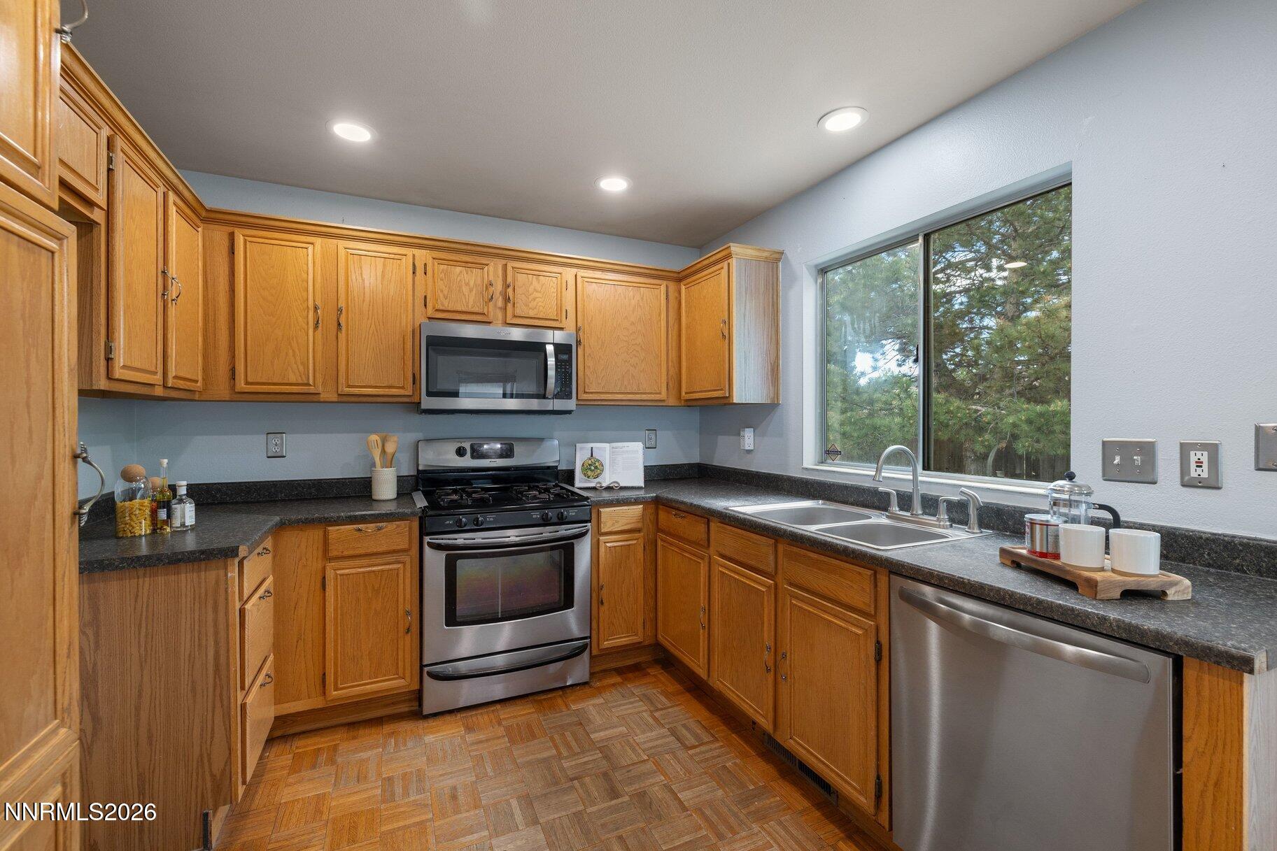 8486 Piper Place Reno, NV 89506 - Photo 8 of 80 a kitchen with stainless steel appliances granite countertop a sink stove and microwave