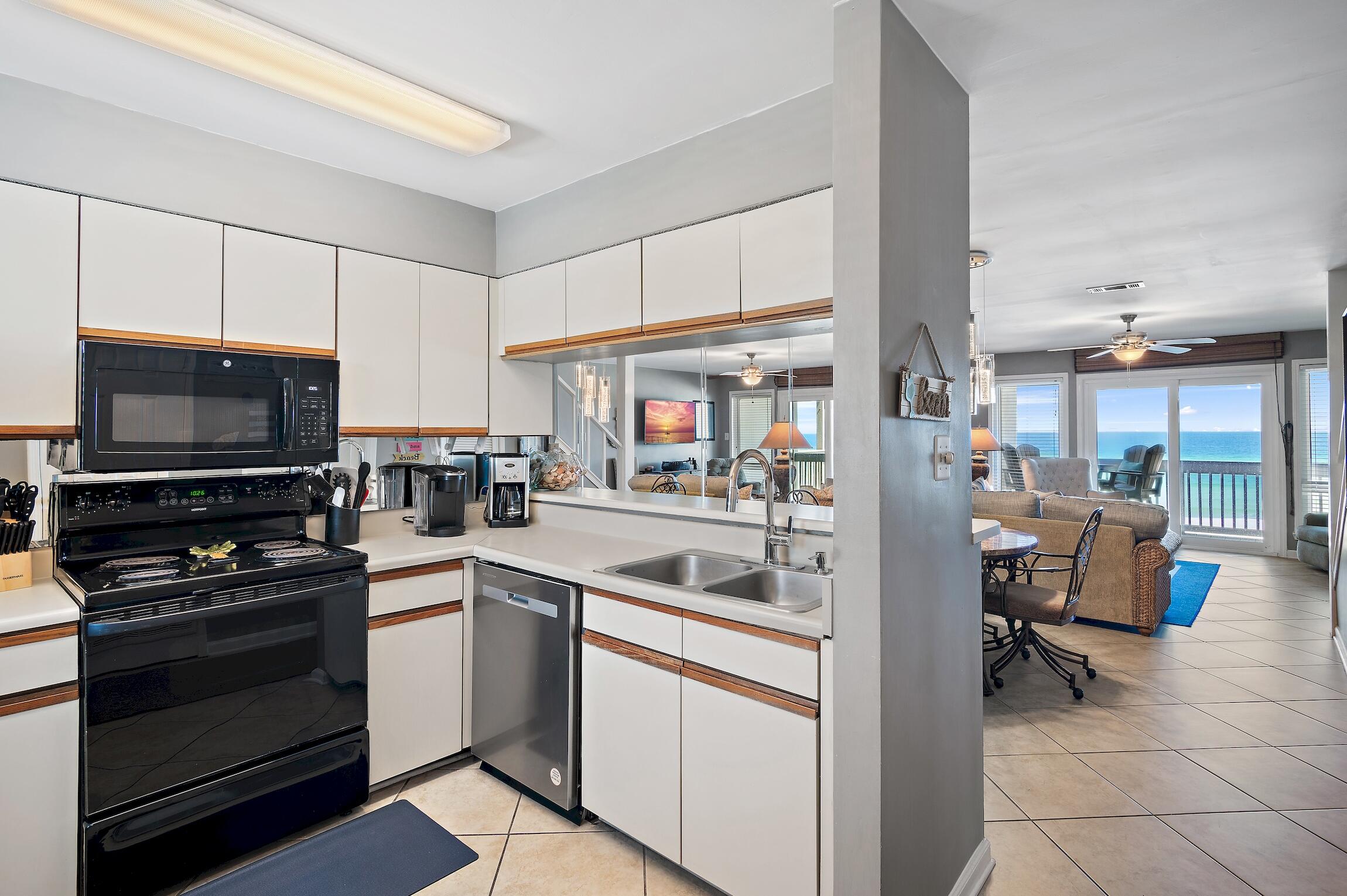 23011 Front Beach Road, Unit 24 Panama City Beach, FL 32413 - Photo 11 of 23 a kitchen with a sink stove and cabinets