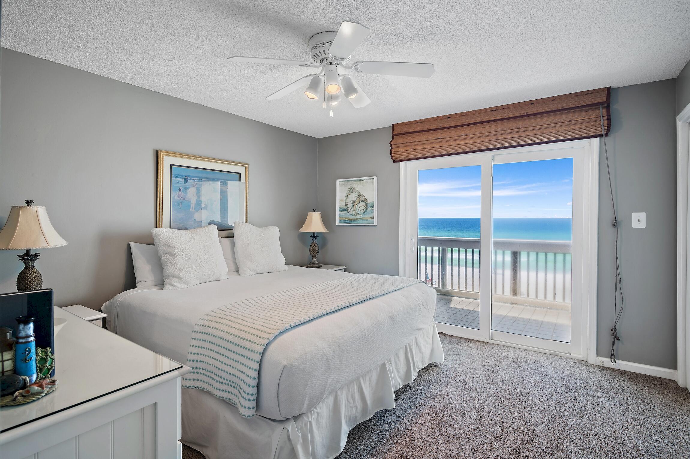 23011 Front Beach Road, Unit 24 Panama City Beach, FL 32413 - Photo 13 of 23 a bedroom with a balcony a bed and a chandelier