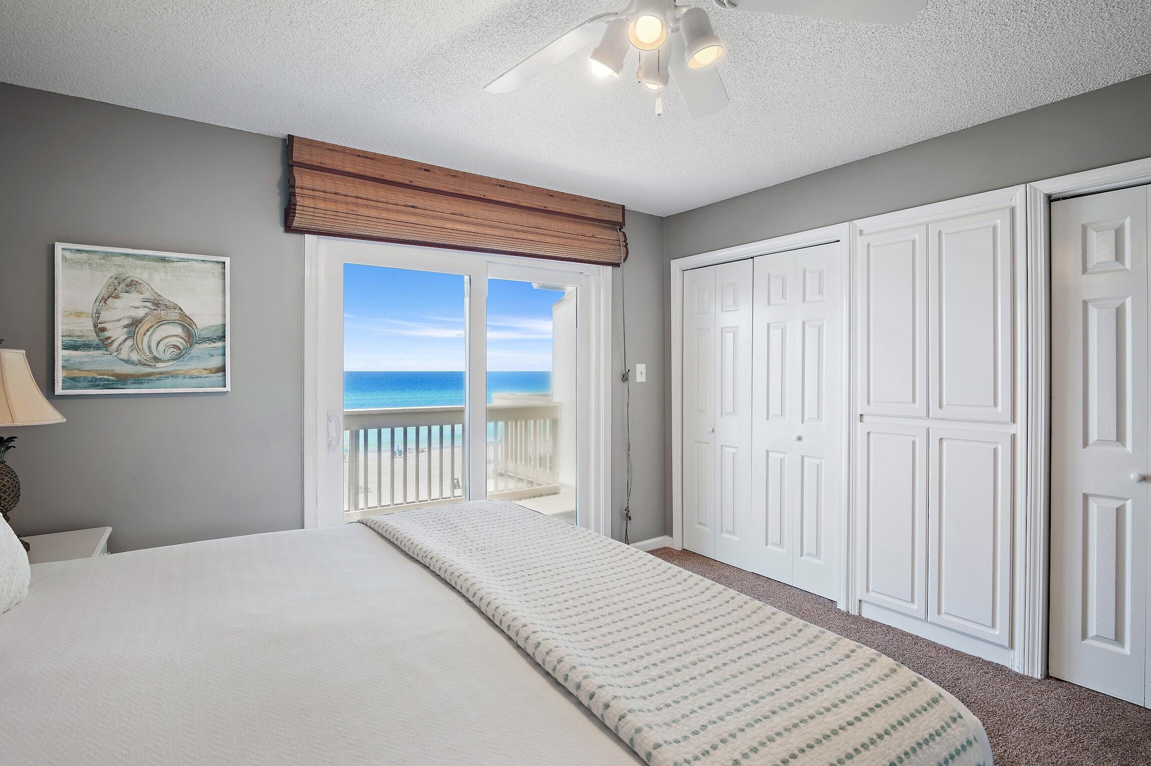 23011 Front Beach Road, Unit 24 Panama City Beach, FL 32413 - Photo 14 of 23 a bedroom with a bed and a chandelier