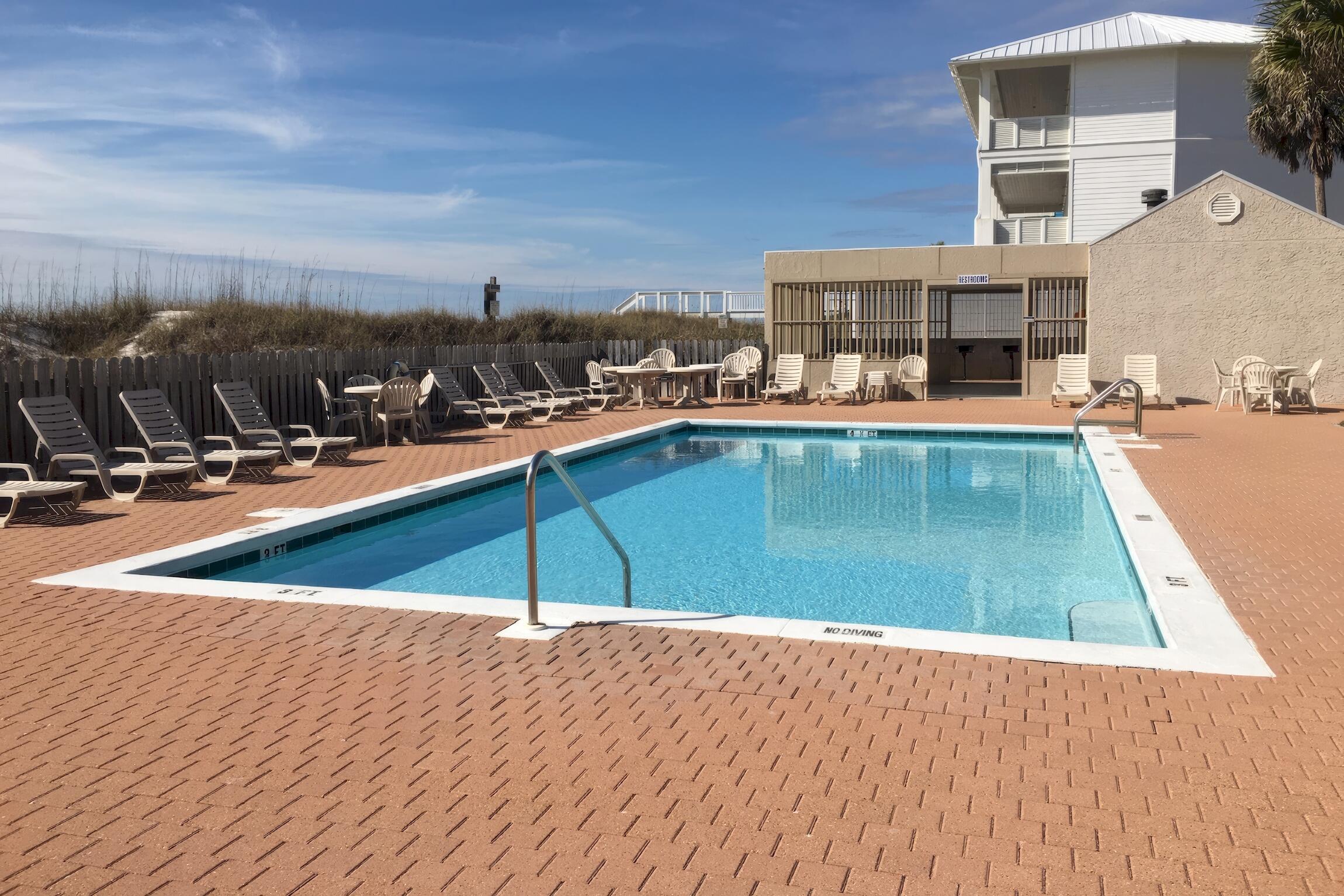 23011 Front Beach Road, Unit 24 Panama City Beach, FL 32413 - Photo 20 of 23 a view of a swimming pool with a lounge chair