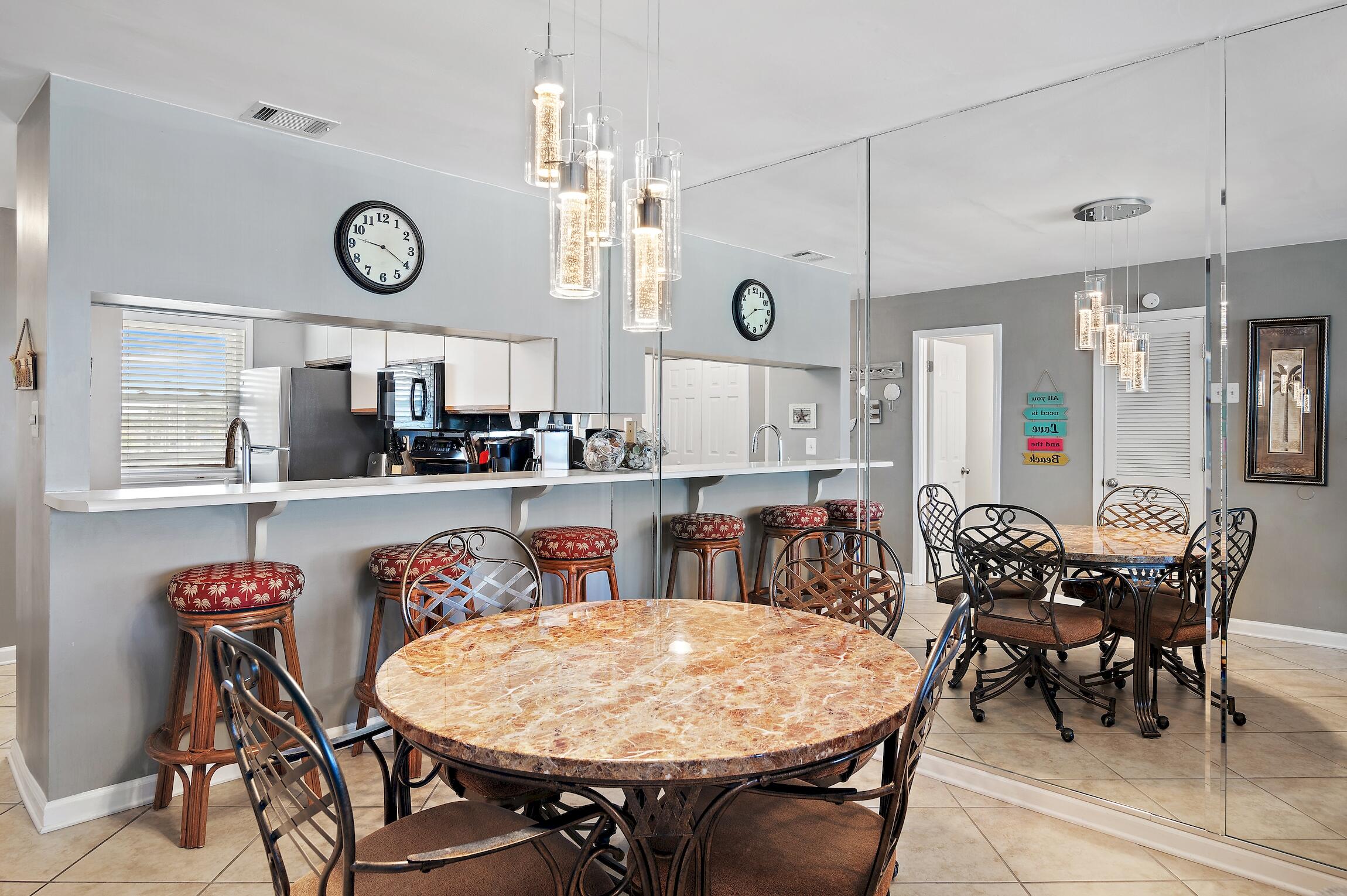 23011 Front Beach Road, Unit 24 Panama City Beach, FL 32413 - Photo 8 of 23 a view of a dining area with furniture and a clock
