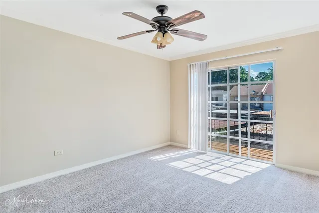 a view of a room with a window and a ceiling fan