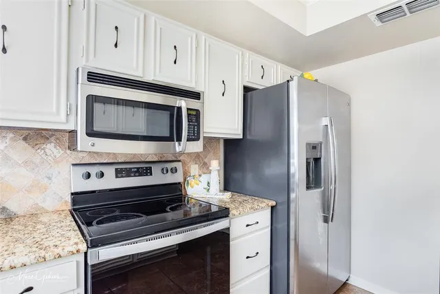a kitchen with stainless steel appliances a stove a microwave and a refrigerator