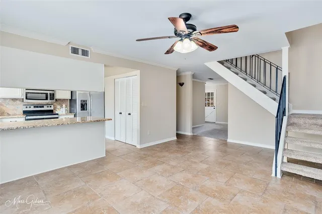 a view of a livingroom with kitchen and stainless steel appliances