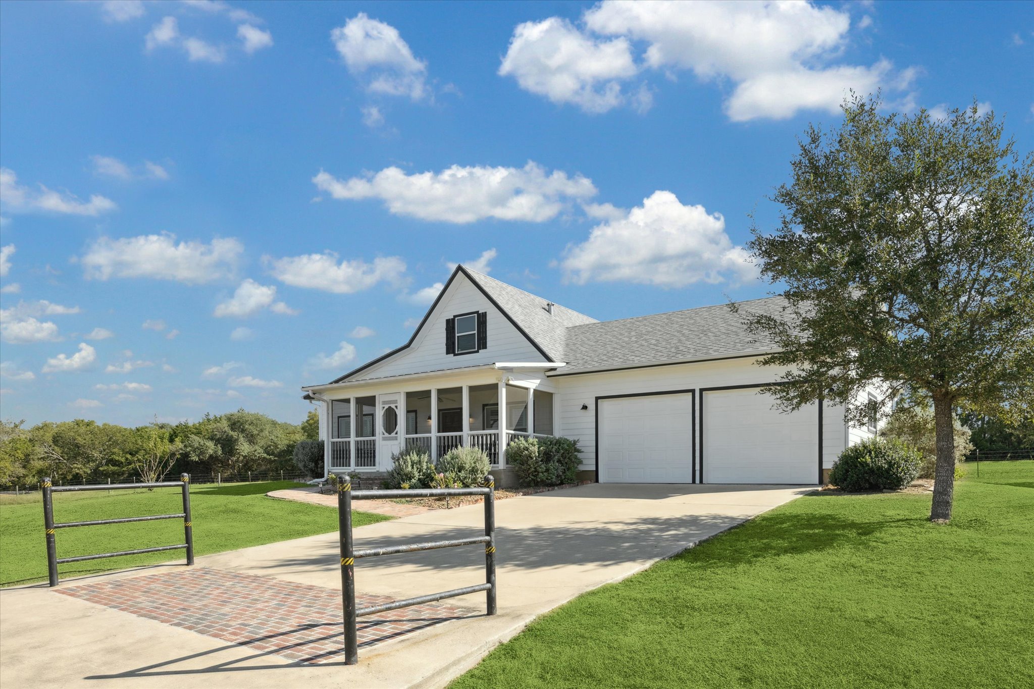 5100 Jaeger Road Burton, TX 77835 - Photo 3 of 34 View of front of property featuring a front lawn, concrete driveway, covered porch, and a garage