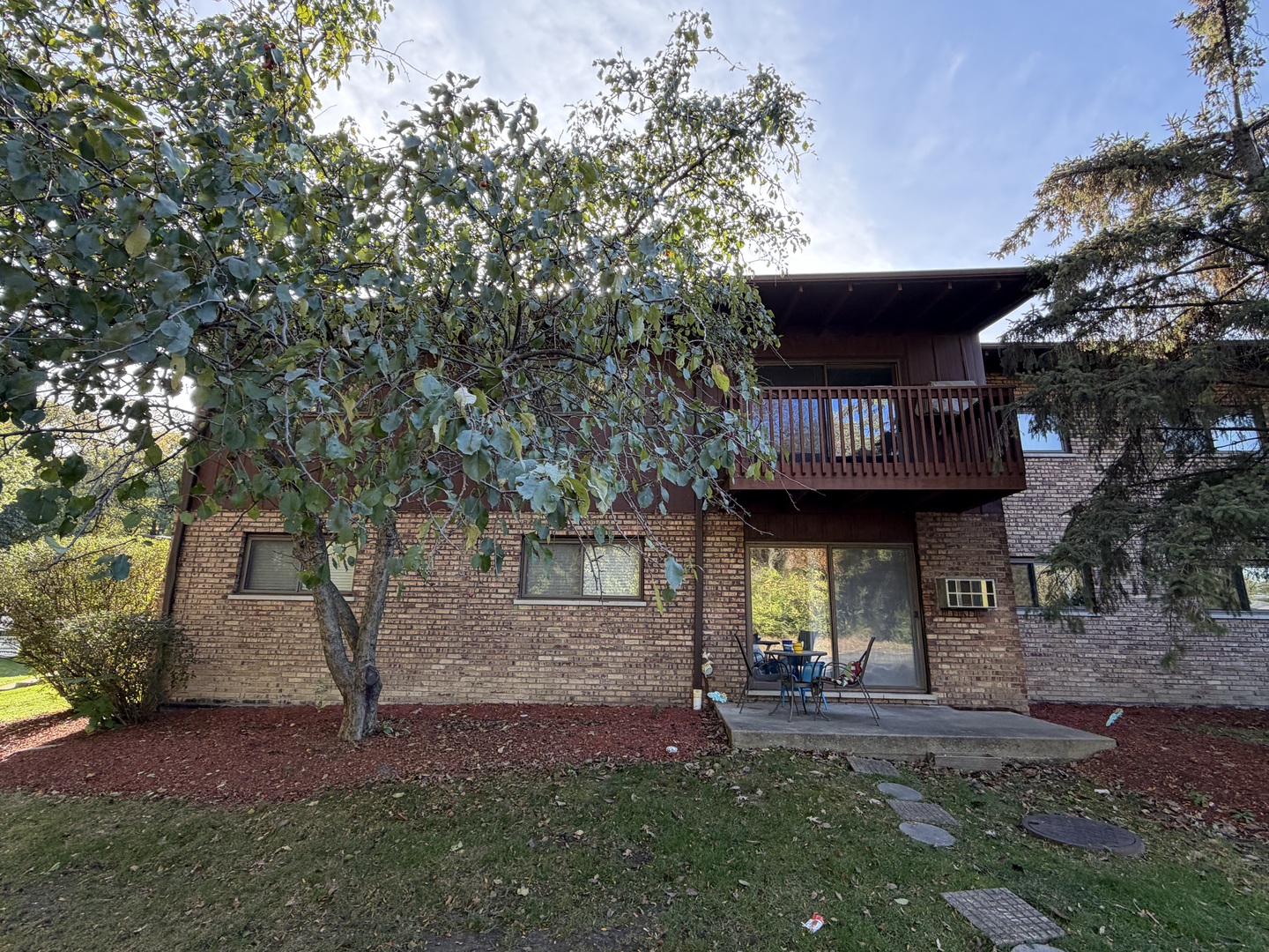a view of a house with brick walls and a tree
