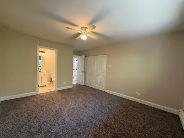 an empty room with closet and a ceiling fan