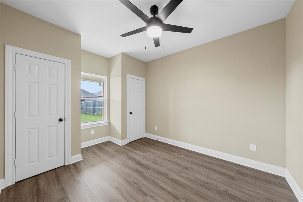 929 Northern Dancer Drive Hewitt, TX 76643 - Photo 22 of 36 an empty room with wooden floor and a ceiling fan