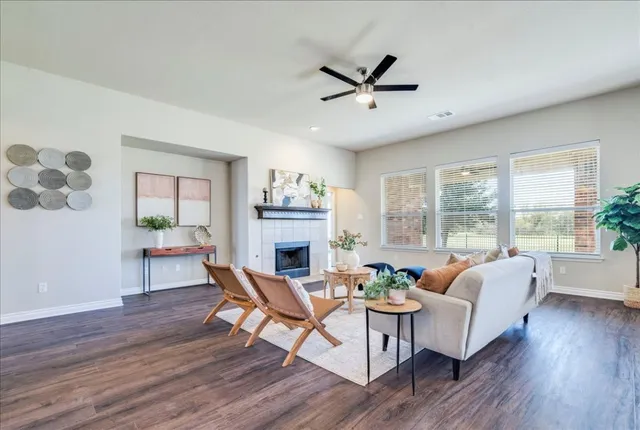 a living room with furniture a fireplace and a floor to ceiling window
