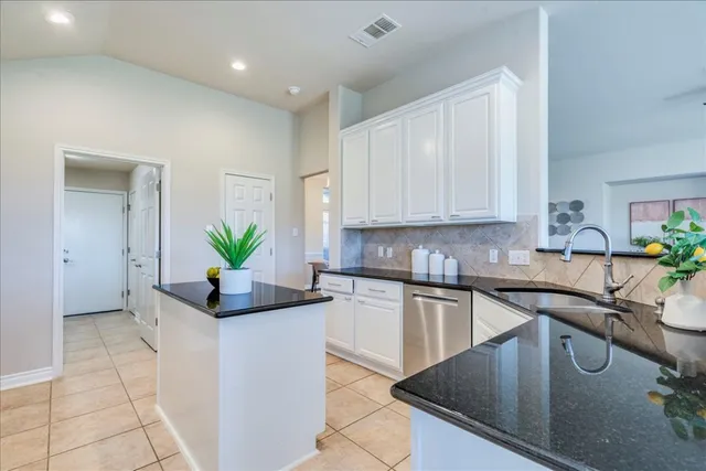 a kitchen with a sink a white counter and cabinets