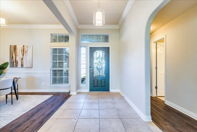 a dining room with wooden floor and a chandelier