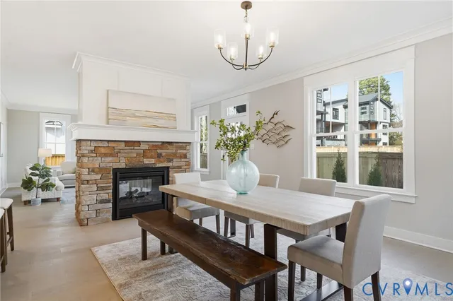a dining room with furniture a fireplace and wooden floor