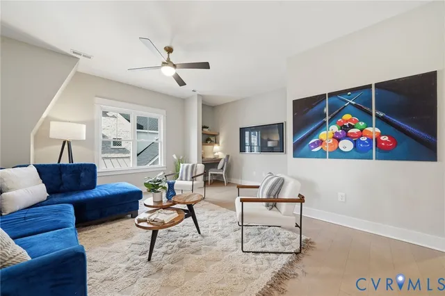 a living room with furniture a rug and a wall painting