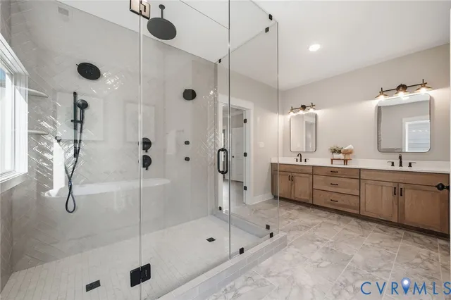 a bathroom with a tub sink mirror and shower