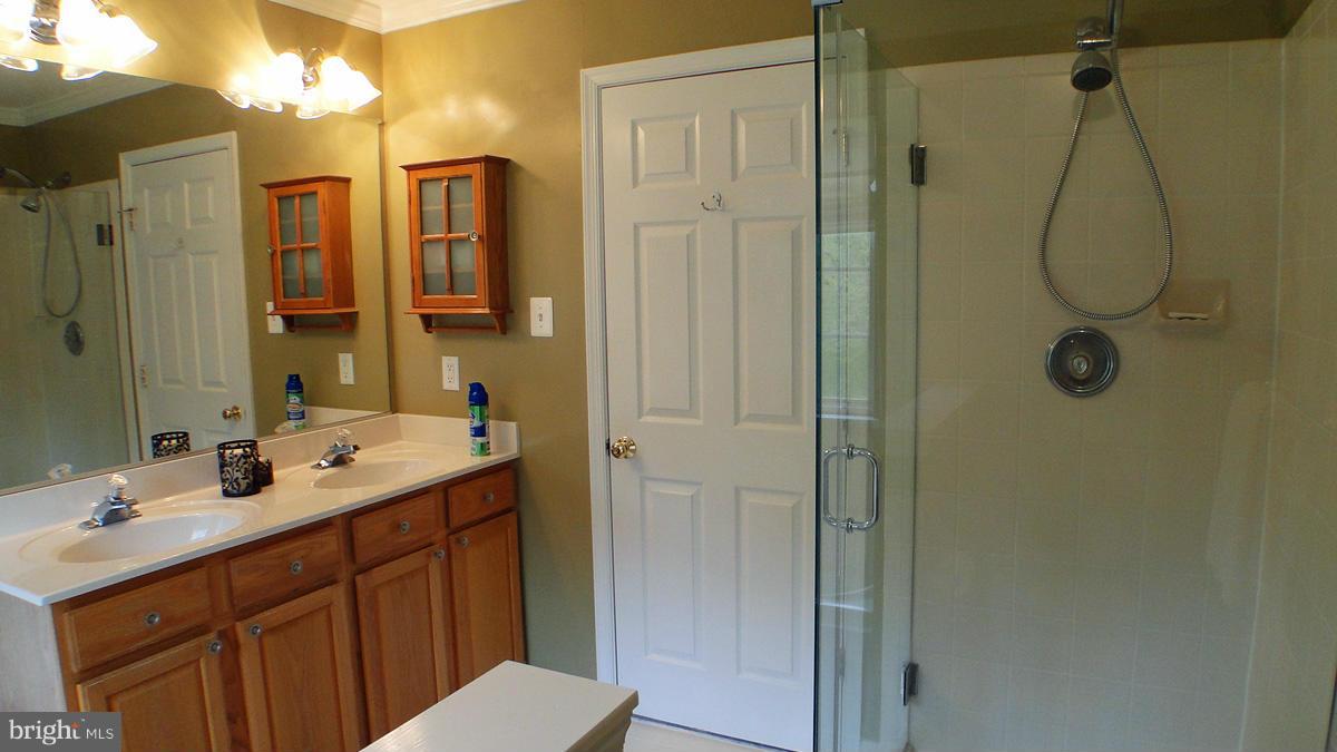 7671 Swallow Road Sykesville, MD 21784 - Photo 15 of 30 a bathroom with a double vanity sink mirror and shower