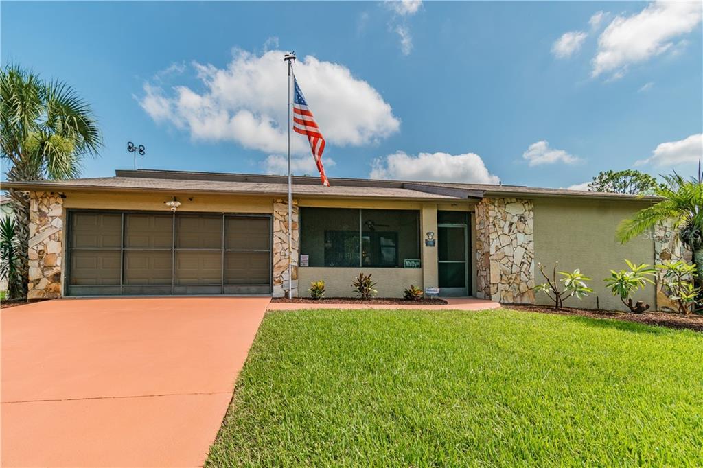 13613 Whitby Road Hudson, FL 34667 - Photo 1 of 1 a front view of a house with a yard and outdoor seating