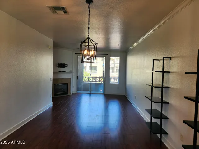 a view of empty room with wooden floor and fireplace
