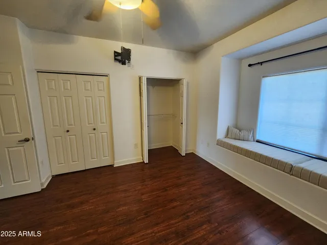 a view of an empty room with wooden floor and closet