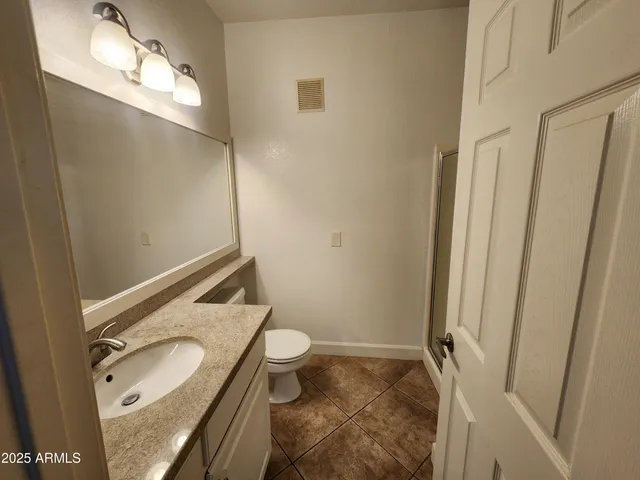 a bathroom with a granite countertop sink toilet and shower curtains