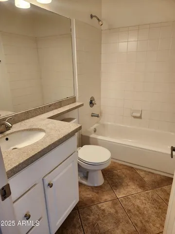 a bathroom with a granite countertop sink a toilet and bathtub