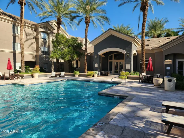 a view of swimming pool with a table and chairs under an umbrella