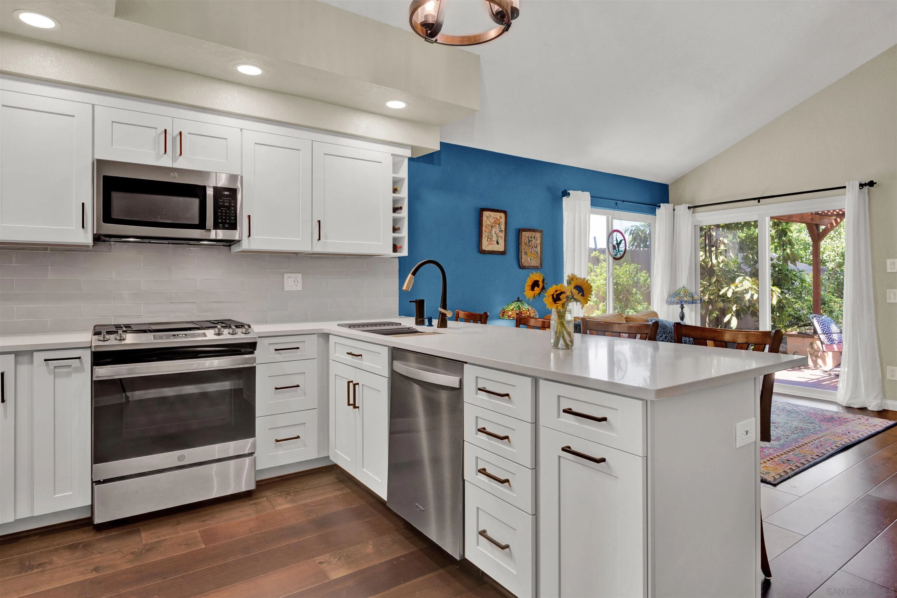 a kitchen with stainless steel appliances white cabinets a sink and a stove