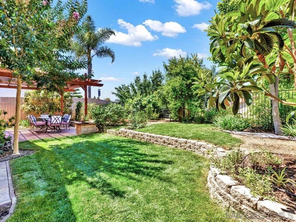 1591 Madrid Drive Vista, CA 92081 - Photo 31 of 40 a backyard of a house with table and chairs plants and large tree