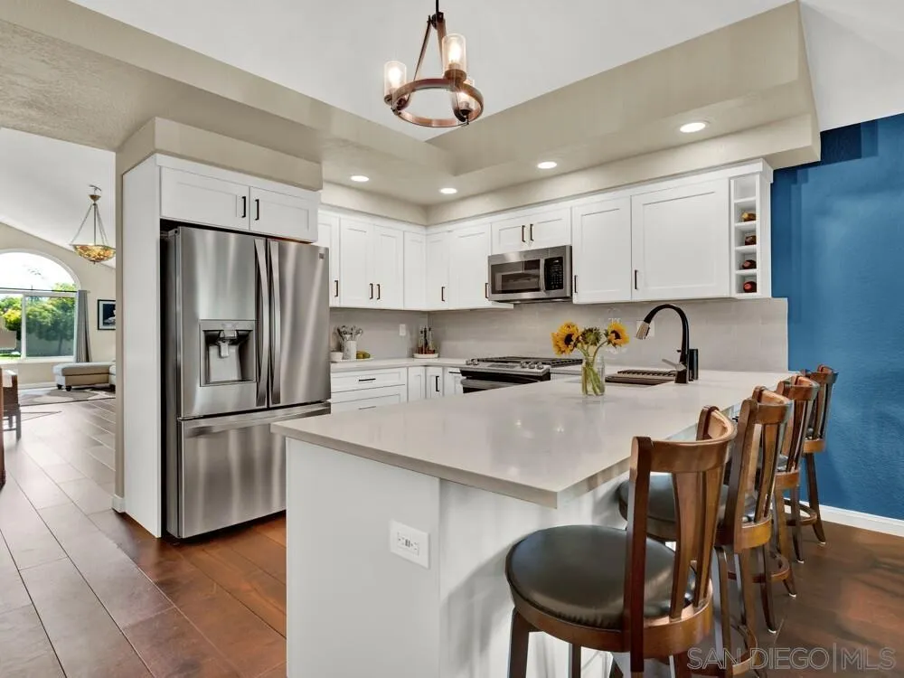 1591 Madrid Drive Vista, CA 92081 - Photo 7 of 40 a kitchen with stainless steel appliances granite countertop a refrigerator a stove a sink a dining table and chairs