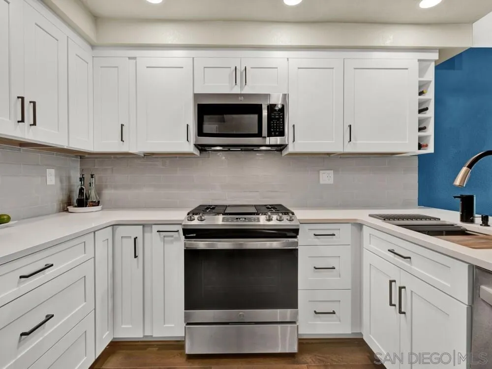 1591 Madrid Drive Vista, CA 92081 - Photo 8 of 40 a kitchen with white cabinets and stainless steel appliances