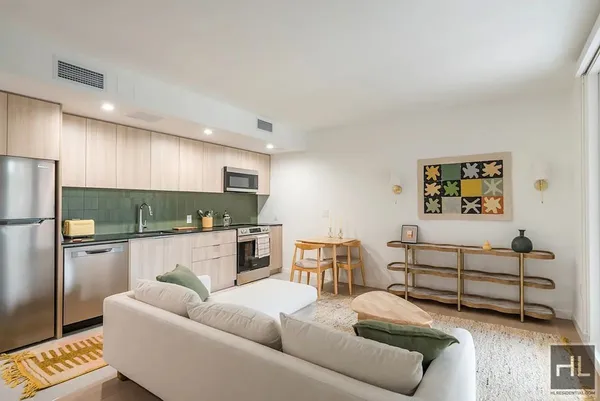a living room with furniture and a kitchen view