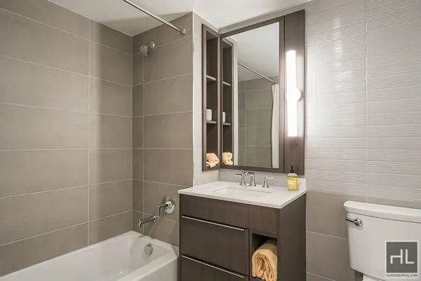 a bathroom with a bathtub shower sink vanity and toilet