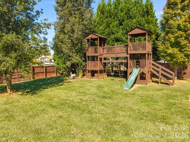 a view of a swimming pool with a patio and a yard