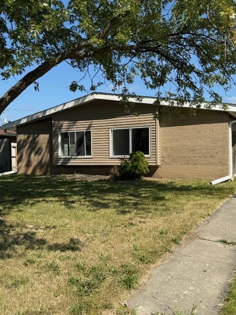 2421 B Lewis Avenue, Unit 2421B Zion, IL 60099 - Photo 1 of 8 a front view of a house with a yard