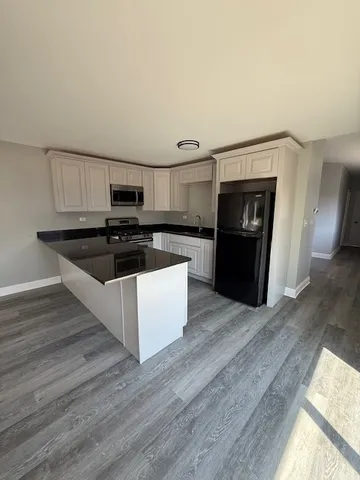 a kitchen with granite countertop a stove top oven and sink