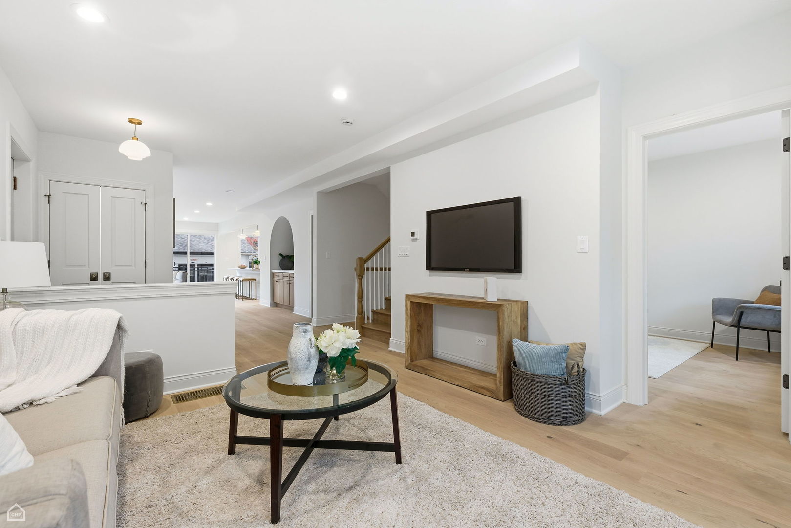 Undisclosed Address Chicago, IL 60625 - Photo 4 of 36 a living room with furniture a flat screen tv and kitchen view