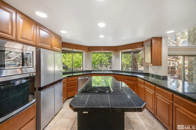 a kitchen with large window and stainless steel appliances