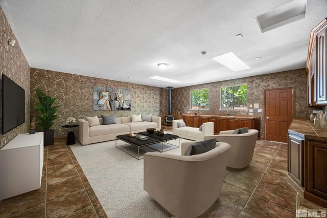 a living room with furniture a large window and a fireplace