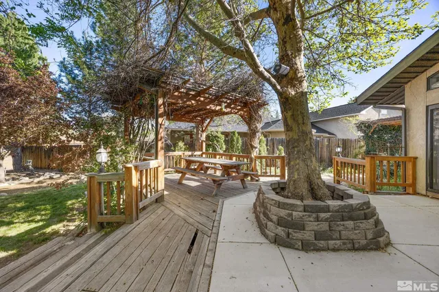 a view of a patio with table and chairs potted plants and large tree