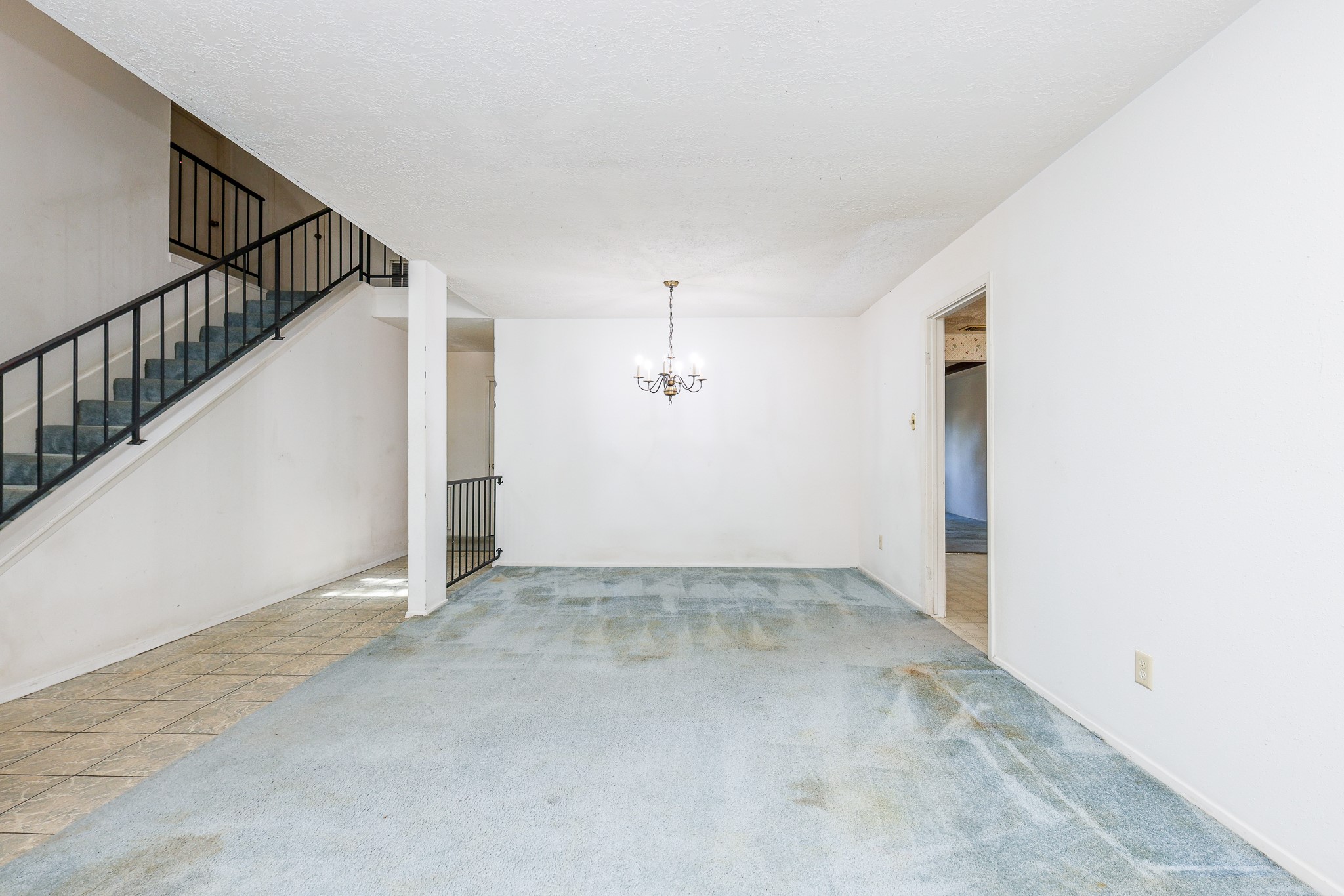 21422 Bridgepoint Lane Spring, TX 77388 - Photo 4 of 20 Spacious interior with a carpeted floor and elegant chandelier, featuring an open staircase with sleek railing, perfect for a modern touch.