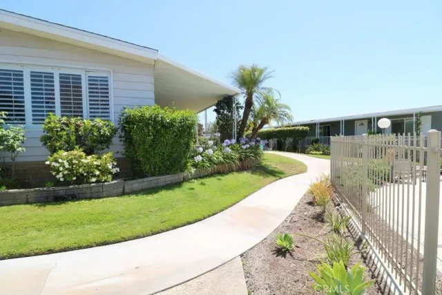a view of a house with a yard and potted plants