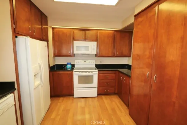 a kitchen with white cabinets and white appliances