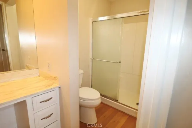 a bathroom with a granite countertop shower and a toilet
