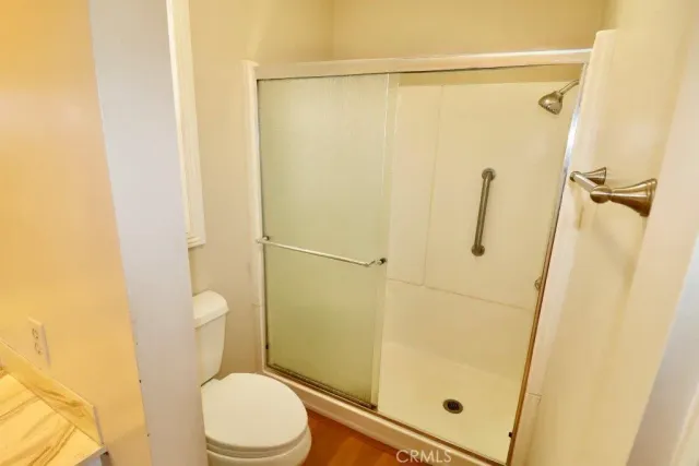 a white toilet sitting next to a shower