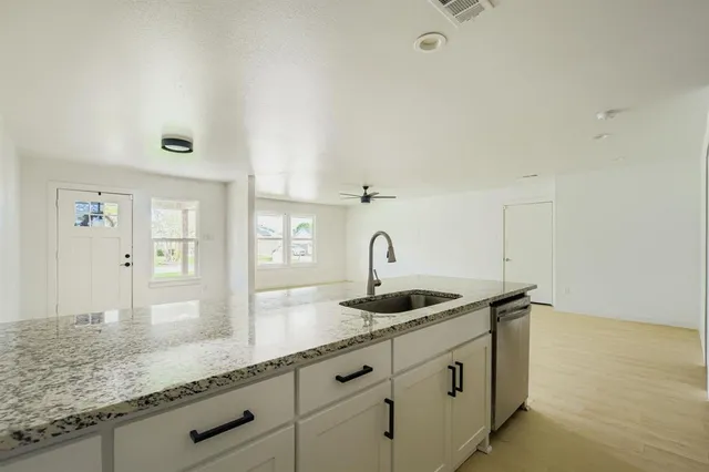 a kitchen with granite countertop a sink and cabinets