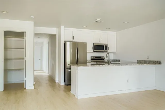 a kitchen with stainless steel appliances granite countertop a refrigerator and a stove