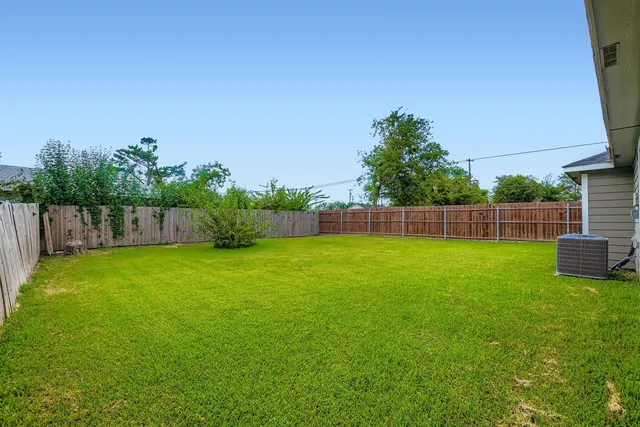 a view of yard with green space and wooden fence